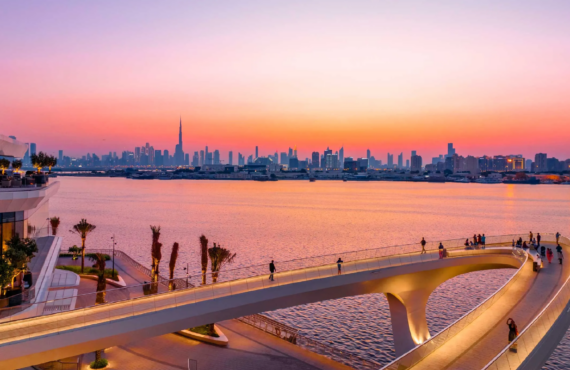Creek Haven by Emaar – sunset view with waterfront promenade, people walking, and Burj Khalifa in the distance.
