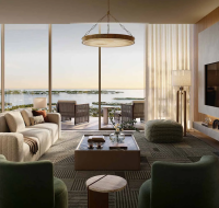 Elegant curved glass apartments with landscaped outdoor dining area and Dubai skyline view.