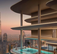 Modern tower with curved design, landscaped terrace, and cityscape in background.