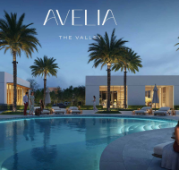 Residents enjoying the paved walkways and green open spaces of Avelia at The Valley, with modern white villas in the background.