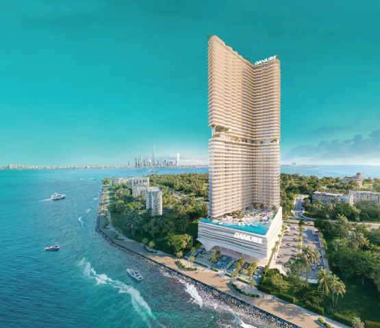 The BREEZ tower in Dubai Maritime City, showing its unique architectural design and proximity to the sea and Dubai skyline.