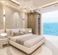 Contemporary bedroom interior featuring a curved bed, textured walls, and wood accents with a stunning sea view.