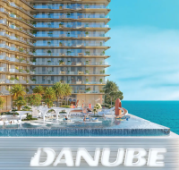 Waterfront buildings and leisure deck in Dubai Maritime City , featuring an outdoor pool with slides and tropical landscaping.