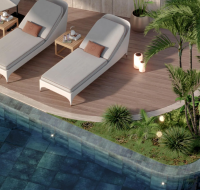 Poolside sun loungers with wooden deck and tropical landscaping beside a modern swimming pool
