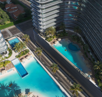 Aerial view of luxury pools surrounded by high-rise buildings and palm trees