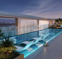 Modern rooftop pool at night with city skyline views.