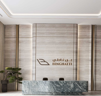 Modern lobby with a marble reception desk, stone wall panels, and soft ambient lighting.