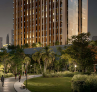 High-rise tower with people walking along landscaped urban paths at dusk