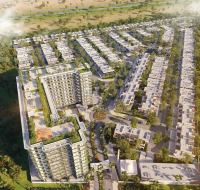 Aerial view of a large residential master community featuring low-rise villas and two modern apartment buildings surrounded by greenery.