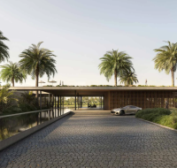 An elegant drop-off area with a modern canopy, cobblestone path, and a lush, landscaped environment.