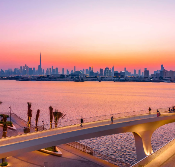 Creek Haven by Emaar – sunset view with waterfront promenade, people walking, and Burj Khalifa in the distance.