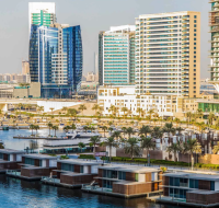 A bustling urban waterway with boats, residential buildings, and a mix of traditional and modern architecture.