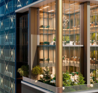 Modern building exterior with tiered glass balconies filled with plants and trees
