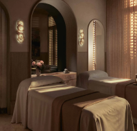 Serene spa treatment room with two beds and soft, warm lighting, part of the wellness facilities.