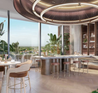 Stylish residents’ lounge with café-style seating, marble bar, and panoramic windows.