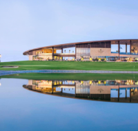 Golf course view near Golf Greens Tower 2 with modern clubhouse and water reflection