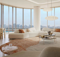 Luxury living room with floor-to-ceiling windows offering stunning skyline and waterfront views.