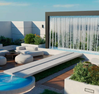 Rooftop lounge area with a modern water wall, circular pool, and white outdoor furniture .