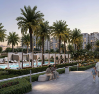 Evening view of a landscaped walkway with families strolling, poolside cabanas, palm trees, and modern residential buildings.