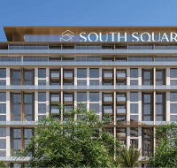 Glass-front building elevation with open balconies and clear blue sky