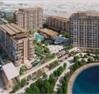 Aerial view of residential complex surrounded by greenery and waterfront walkway