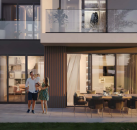 Family enjoying patio area outside modern townhouse at dusk