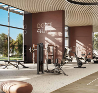Modern fitness center designed by Meraas with high ceilings, large windows, and motivational text on the wall.