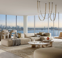 Luxury apartment interior in Dubai Design District with a sleek sectional sofa and dining area overlooking the canal and city skyline.