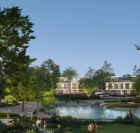 Residential community park featuring a pond, walking paths, mature trees, and modern townhouses in the background.